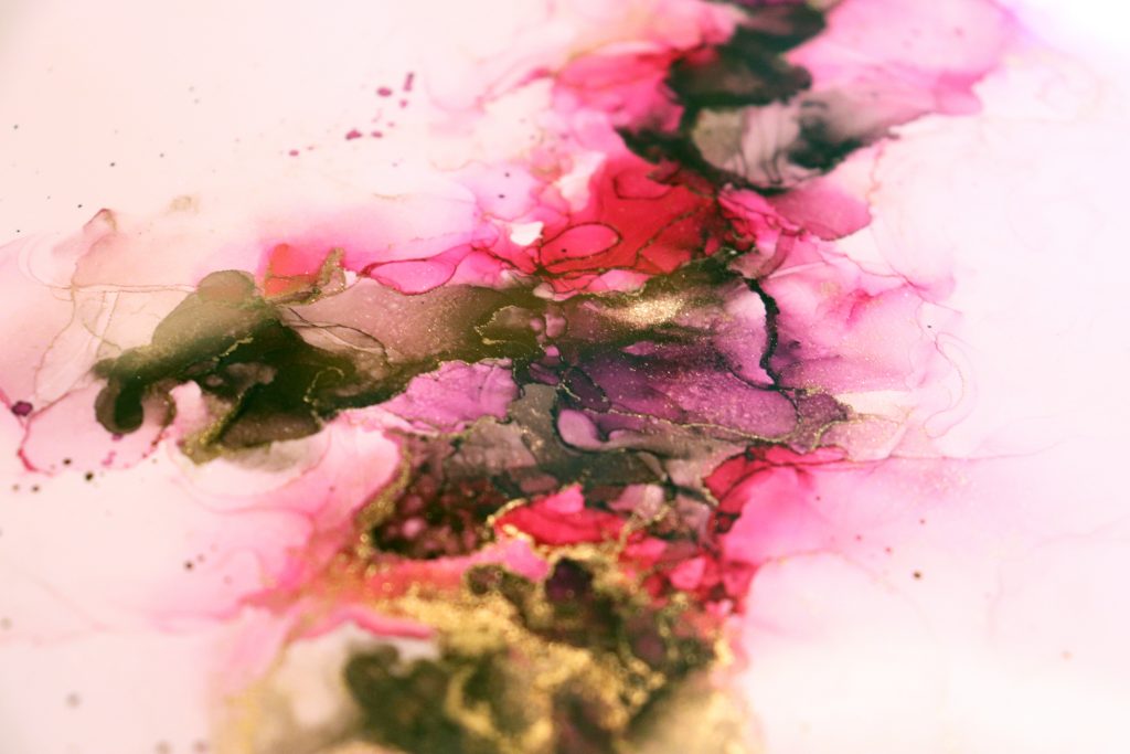 Abstraktes Alkohol-Ink-Gemälde mit fließenden Farbverläufen in Pink, Gold und Dunkelgrün auf hellem Grund.