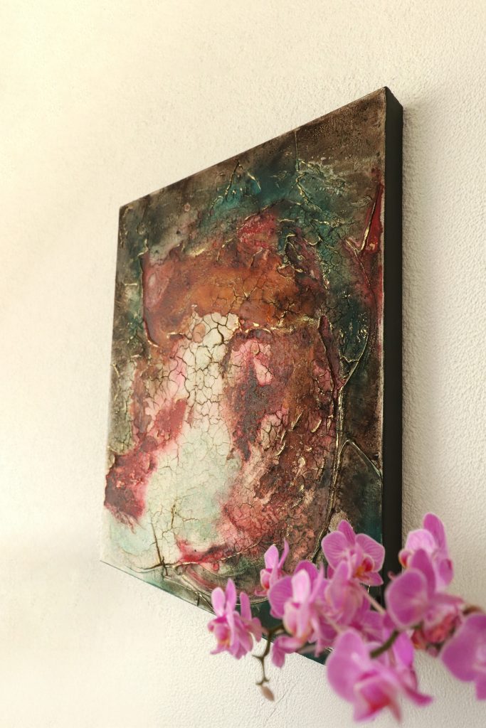 Strukturreiches abstraktes Gemälde mit rissiger Oberfläche, Goldakzenten und pastelligen Farben, im Vordergrund eine Orchidee.